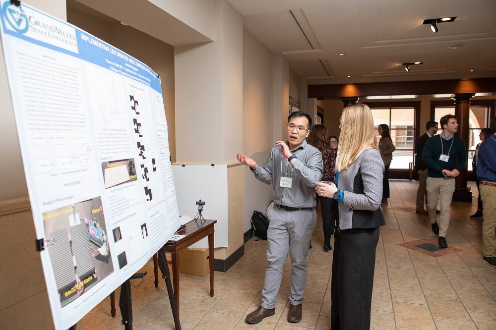 James Nguyen discussing his poster with Trista Bergerud.